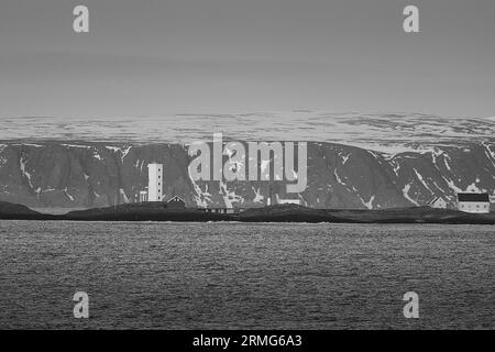 Foto in bianco e nero del faro di Kjølnes, costruito in cemento nel 1916, si trova a 5 km a est di Berlevåg, nell'Artico norvegese Foto Stock