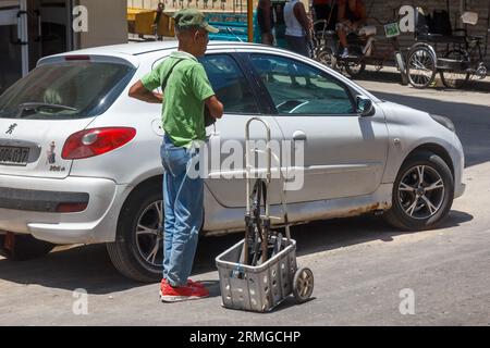 L'Avana, Cuba, 2023 anni, cubano con un carro rustico in strada Foto Stock