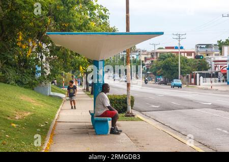 L'Avana, Cuba, 2023, anziano cubano seduto alla fermata dell'autobus Foto Stock