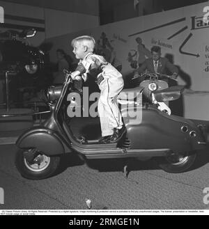 Ragazzo negli anni '1950 In una fiera, un ragazzo è entusiasta mentre è seduto sullo scooter Lambretta. Svezia, settembre 1952. rif. SSMSAX000448L Foto Stock