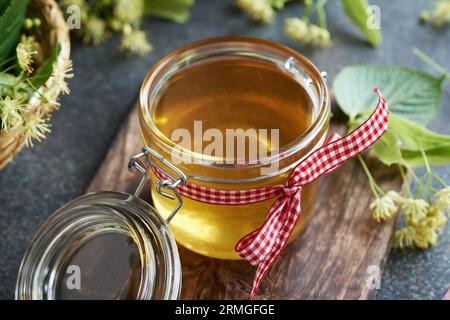 Miele in vaso di vetro con fiori di tiglio o di tilia Foto Stock