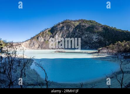 Il cratere vulcanico con acqua acida blu latte a Kawah Putih, o il cratere bianco, con il monte Patuha sullo sfondo. Giava, Indonesia. Foto Stock