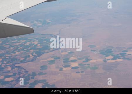 Vista dall'aeroplano delle terre coltivate sottostanti, compresa l'irrigazione a perno centrale nella parte occidentale degli Stati Uniti. Foto Stock