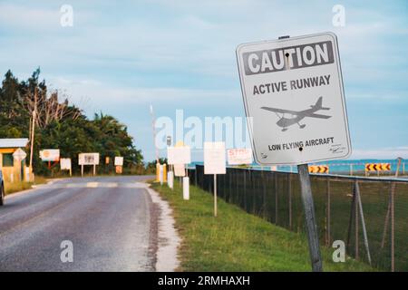 La segnaletica avverte i veicoli a motore di aerei a bassa quota all'aeroporto di Placencia, Belize Foto Stock