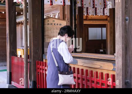 Giappone, Kyushu, Fukuoka, Hakata. Adoratore che prega al santuario shintoista Kushida Foto Stock