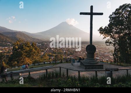 Una vista del vulcano Agua dalla Collina della Croce, un punto panoramico con una croce di legno che si affaccia sulla storica città di Antigua Guatemala Foto Stock