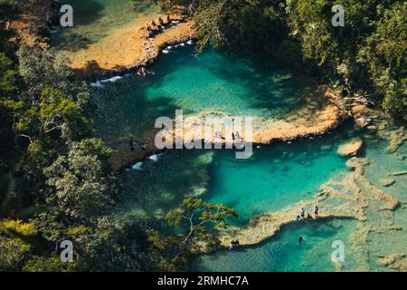 I turisti nuotano e si godono le piscine turchesi sul fiume Cahabón nel Semuc Champey Natural Monument, Guatemala Foto Stock