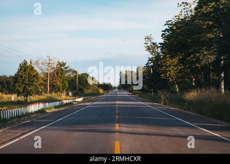 Una lunga strada rettilinea e vuota a corsia singola in buone condizioni vicino a Las Cruces nel nord del Guatemala Foto Stock