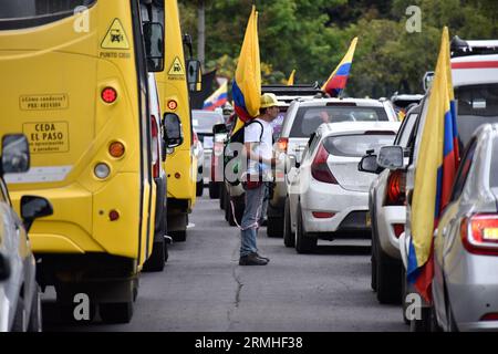 Bogotà, Colombia. 28 agosto 2023. Un uomo detiene una bandiera colombiana tra le auto durante le proteste contro l'aumento dei prezzi del carburante, a Bogotà, in Colombia, il 28 agosto 2023. Foto di: Cristian Bayona/Long Visual Press Credit: Long Visual Press/Alamy Live News Foto Stock