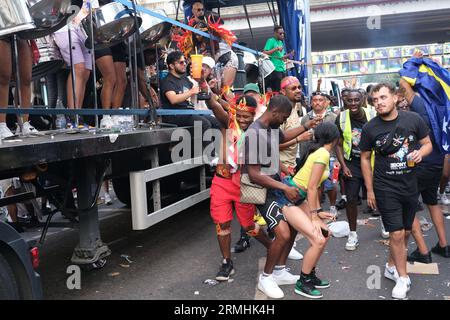 I giovani ballano accanto a un camion che fa esplodere musica durante la celebrazione del Carnevale di Notting Hill della cultura caraibica. 28/08/2023 Foto Stock