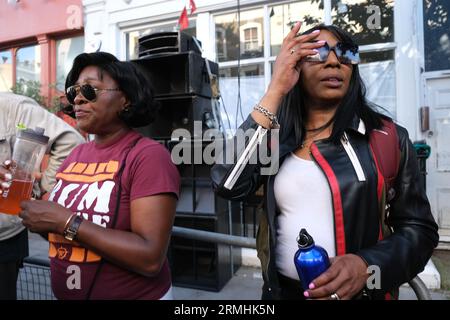 Due donne ascoltano la musica da un sistema audio al Carnevale di Notting Hill il lunedì delle festività di Londra. 28/08/2023 Foto Stock