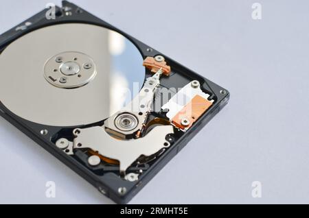 Dettaglio di un disco fisso per notebook evidenziato, a simboleggiare il supporto tecnico e il progresso tecnologico. Concetto tra assistenza tecnica e tecnologia Foto Stock