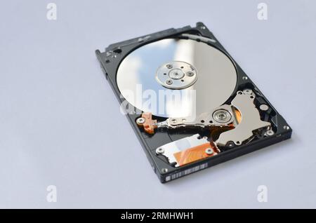 Dettaglio di un disco fisso per notebook evidenziato, a simboleggiare il supporto tecnico e il progresso tecnologico. Concetto tra assistenza tecnica e tecnologia Foto Stock