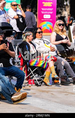 Edmonton, Alberta, Canada. 22 agosto 2023. Una ballerina jingle siede dopo la sua gara al 2 Spirit PowWow. Mentre il weekend Pride inizia a Edmonton, la comunità indigena riconosce l'evento con il 2 Spirit Powwow. Il termine due-Spirito è una traduzione diretta del termine Ojibwe, Niizh manidoowag. Il termine "a due spiriti" o "a due spiriti" è solitamente usato per indicare una persona il cui corpo ospita contemporaneamente uno spirito maschile e uno spirito femminile. Una parte della celebrazione è l'inclusività di tutti e l'accoglienza di tutti per festeggiare partecipando a una danza jig. Tutti i partecipanti sono invitati Foto Stock