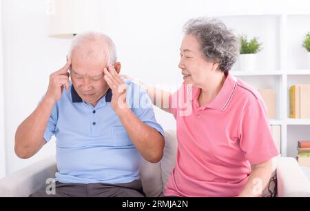 donna anziana che consola il suo triste marito a casa. Foto Stock