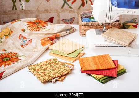 Preparazione e selezione di tessuti per cucire trapunte patchwork su una macchina da cucire elettrica Foto Stock