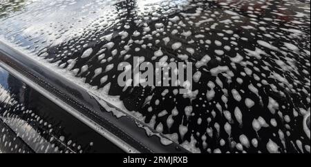 Autolavaggio. Schiuma sull'auto nel autolavaggio. Pulizia dell'auto. Foto Stock