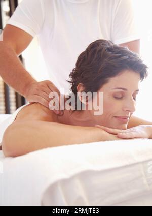 Maschio terapista di massaggio donna massaggio sulle spalle all'aperto Foto Stock