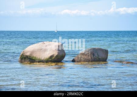 Pietra singola, roccia nel Mar Baltico sotto il sole. Foto del paesaggio dalla costa. Foto Stock