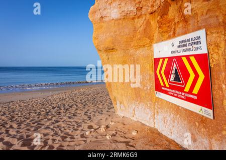 SCOGLIERE INSTABILI A CADUTA ROCCIOSA, MANTENERE Una DISTANZA DI SICUREZZA è scritto in inglese su un cartello di avvertimento in Portogallo sulle scogliere dell'Oceano Atlantico. Rocce e. Foto Stock