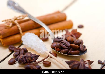 Caffè, zucchero e spezie su un cucchiaio d'argento su un tavolo rustico in legno bianco Foto Stock