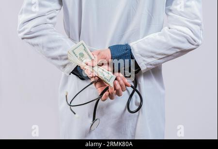 Corruzione medica e concetto di corruzione. Un medico corrotto che nasconde i soldi, un medico disonesto che nasconde i soldi Foto Stock