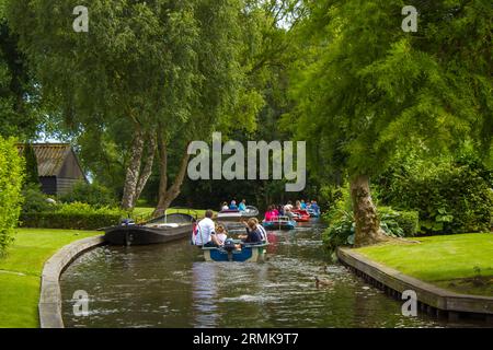 GIETHOORN, PAESI BASSI - AGOSTO 01 2017: Visitatori sconosciuti nel giro turistico in barca in un canale a Giethoorn. Le belle case e il giardinaggio Foto Stock