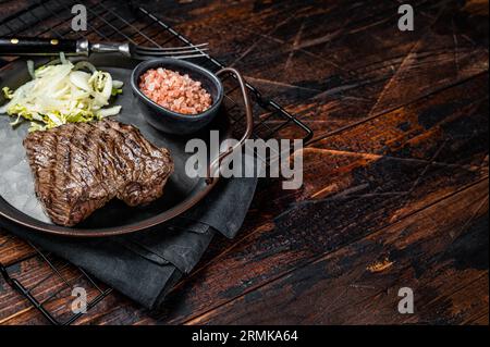 Bistecca di cervo con sale marino e insalata. Sfondo di legno. Vista dall'alto. Copia spazio. Foto Stock