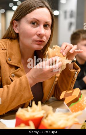 Ivano-Frankivsk, Ucraina 7 giugno 2023: Una giovane ragazza mangia un hamburger da McDonald's.. Foto Stock