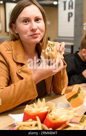 Ivano-Frankivsk, Ucraina 7 giugno 2023: Una giovane ragazza mangia un hamburger da McDonald's.. Foto Stock