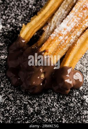 Churros vista alta con cioccolato di zucchero Foto Stock