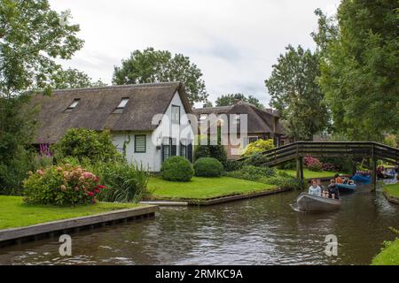 GIETHOORN, PAESI BASSI - AGOSTO 01 2017: Visitatori sconosciuti nel giro turistico in barca in un canale a Giethoorn. Le belle case e il giardinaggio Foto Stock