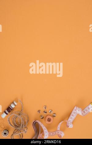 Pulsante della corda di iuta della spola con nastro di misurazione sfondo arancione Foto Stock