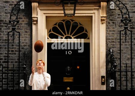Jake Barraclough lancia una palla di rugby fuori dal 10 di Downing Street, Londra, mentre segna il 200° anniversario della creazione del gioco di rugby correndo i 450 km dalla Rugby School a Parigi, prima della Coppa del mondo di rugby in Francia. Data foto: Martedì 29 agosto 2023. Foto Stock