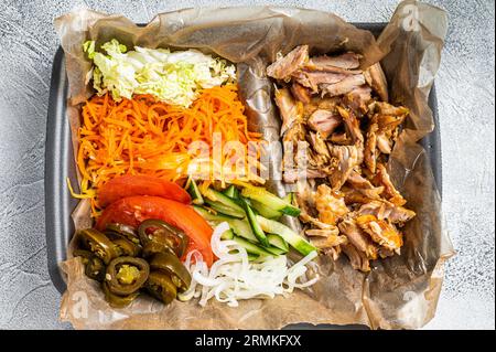 Doner kebab Shawarma su un piatto con patatine fritte e insalata in scatola per andare, da asporto. Sfondo bianco. Vista dall'alto. Foto Stock