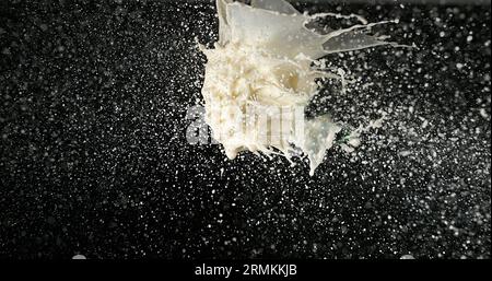 Esplosione del latte su sfondo nero Foto Stock