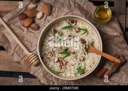 Couscous con noci, foglie di marijuana e olio di cannabis in una ciotola su fondo di legno Foto Stock