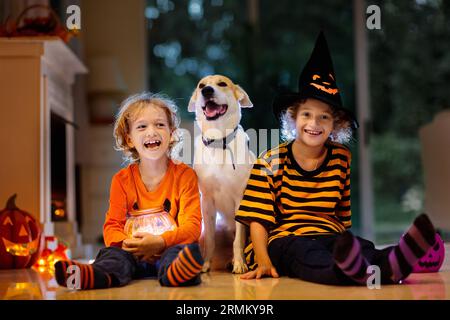 Bambina e ragazzo in costume strega su Halloween trucco o trattare. I bambini tengono la caramella nel secchio della lanterna di zucca. I bambini festeggiano Halloween Foto Stock