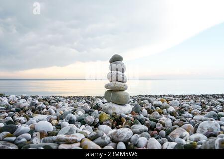 Torre in pietra sulla spiaggia. Cairn. Simbolo di equilibrio. Foto Stock