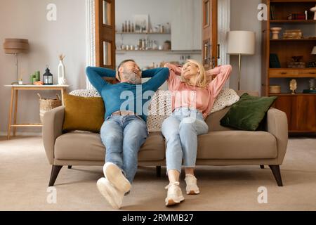 Una felice coppia matura che si rilassa sul divano nella Cozy Home Foto Stock