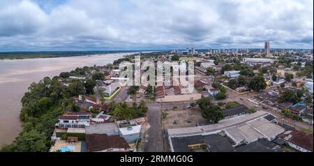 Vista aerea con droni dello skyline del centro di Porto Velho, delle strade, delle piazze e del fiume Madeira. Foresta pluviale amazzonica sullo sfondo nelle nuvole giornate estive. Foto Stock