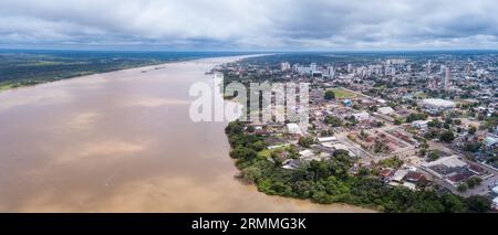 Vista aerea con droni dello skyline del centro di Porto Velho, delle strade, delle piazze e del fiume Madeira. Foresta pluviale amazzonica sullo sfondo nelle nuvole giornate estive. Foto Stock