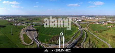 Veduta aerea zenithal di una rotatoria con un arco del ponte sospeso di Santiago Calatrava a Reggio Emilia. Reggio Emilia, Italia Foto Stock