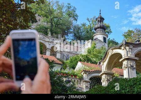 Turisti felici a Praga, Repubblica Ceca, che scattano selfie e foto di un altro passeggero in una giornata di sole durante le loro vacanze. Foto Stock