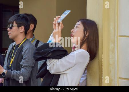 Turisti felici a Praga, Repubblica Ceca, che scattano selfie e foto di un altro passeggero in una giornata di sole durante le loro vacanze. Foto Stock