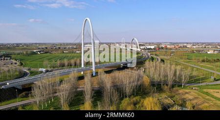 Veduta aerea zenithal di una rotatoria con un arco del ponte sospeso di Santiago Calatrava a Reggio Emilia. Reggio Emilia, Italia Foto Stock