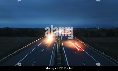 Autostrada a più corsie in campagna al crepuscolo. Trasporto in auto a tema, indicazioni e collegamenti. Foto Stock