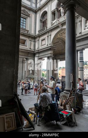 Gli artisti si siedono intorno per dipingere e vendere le loro opere ai turisti in visita al Loggiato, un cortile semi-chiuso, parte della Galleria degli Uffizi (U Foto Stock