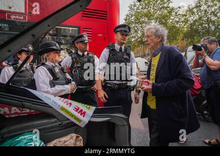 Westminster Londra Regno Unito. 29 agosto 2023. Gli agenti di polizia parlano con Piers Corbyn che sta dimostrando fuori Downing Street contro Ulez il giorno in cui il piano di espansione di Ulez entrerà in vigore nei quartieri di Londra. Il sistema di aria pulita, impopolare tra gli automobilisti, impone un costo giornaliero di £12,50 ai conducenti di alcuni veicoli più vecchi che entrano nella capitale.Credit amer ghazzal/Alamy Live News Foto Stock