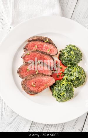 Fianchi la bistecca con gli spinaci cremosi sul piatto Foto Stock